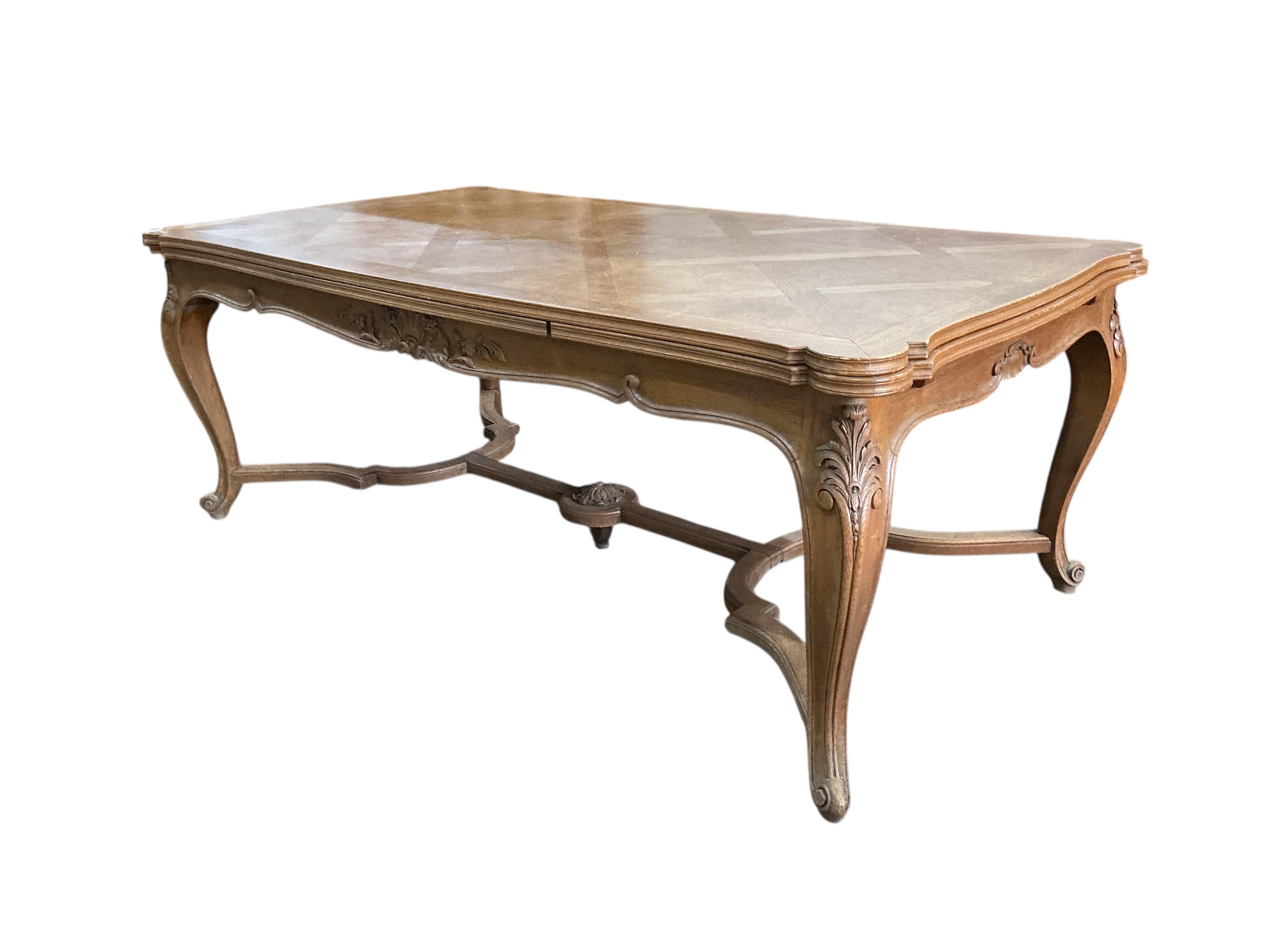 A French rectangular parquetry draw leaf dining table on acanthus carved cabriole legs, width 199cm, (320cm extended), depth 119cm, height 76cm